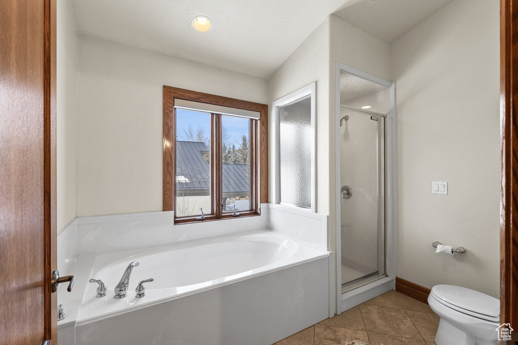 Bathroom with tile flooring, toilet, and plus walk in shower