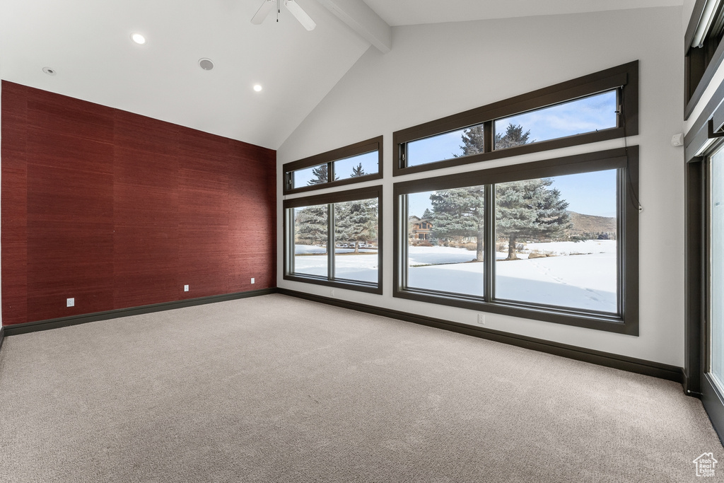 Empty room with plenty of natural light, light carpet, and ceiling fan