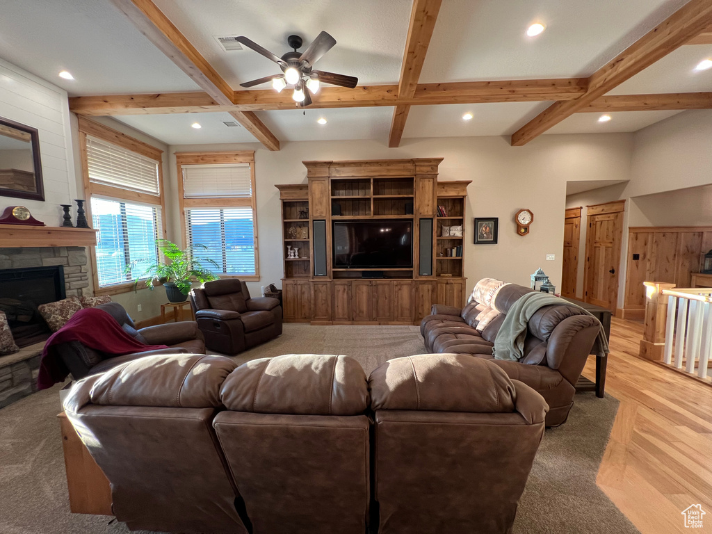 Living room featuring a fireplace, light hardwood / wood-style flooring, beam ceiling, coffered ceiling, and ceiling fan