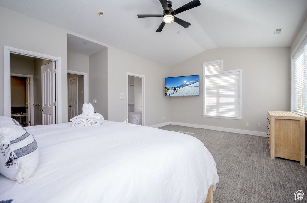 Bedroom featuring light carpet, vaulted ceiling, ceiling fan, and multiple windows