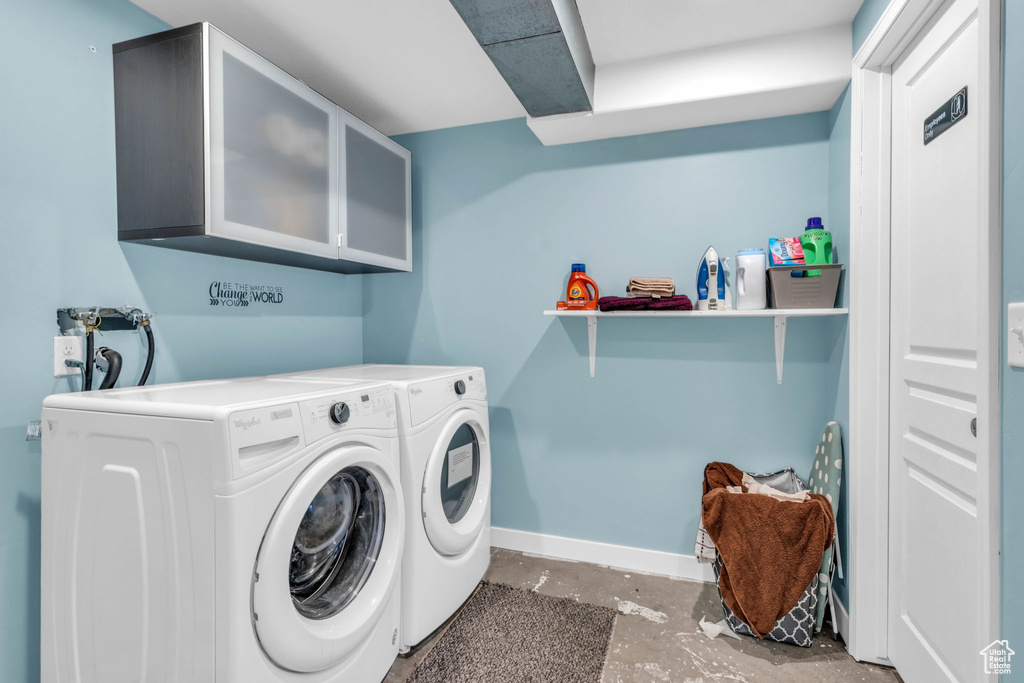 Clothes washing area with independent washer and dryer, washer hookup, and cabinets