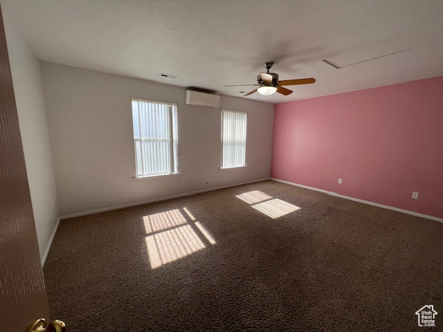 Unfurnished room with ceiling fan, a wall mounted air conditioner, and dark colored carpet