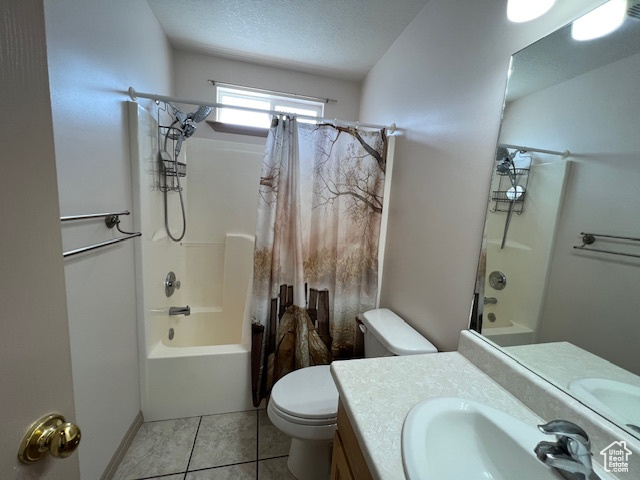Full bathroom with shower / bath combo, vanity with extensive cabinet space, toilet, tile flooring, and a textured ceiling