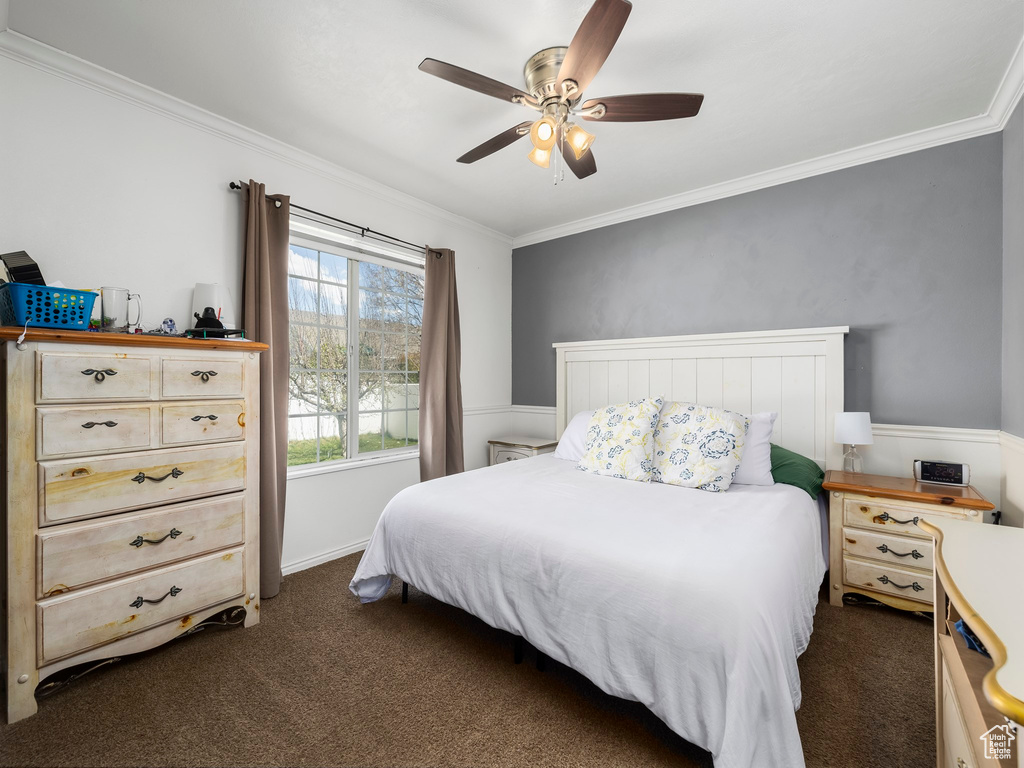 Bedroom featuring ceiling fan, crown molding, and dark colored carpet