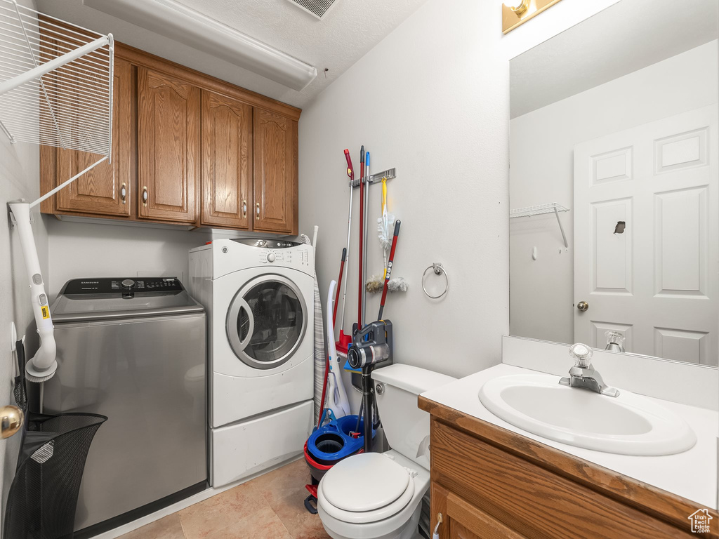 Laundry room featuring sink, separate washer and dryer, and light tile floors