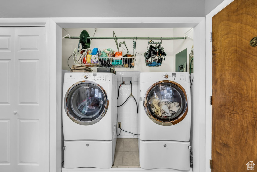 Laundry room with tile flooring, hookup for a washing machine, and washer and clothes dryer