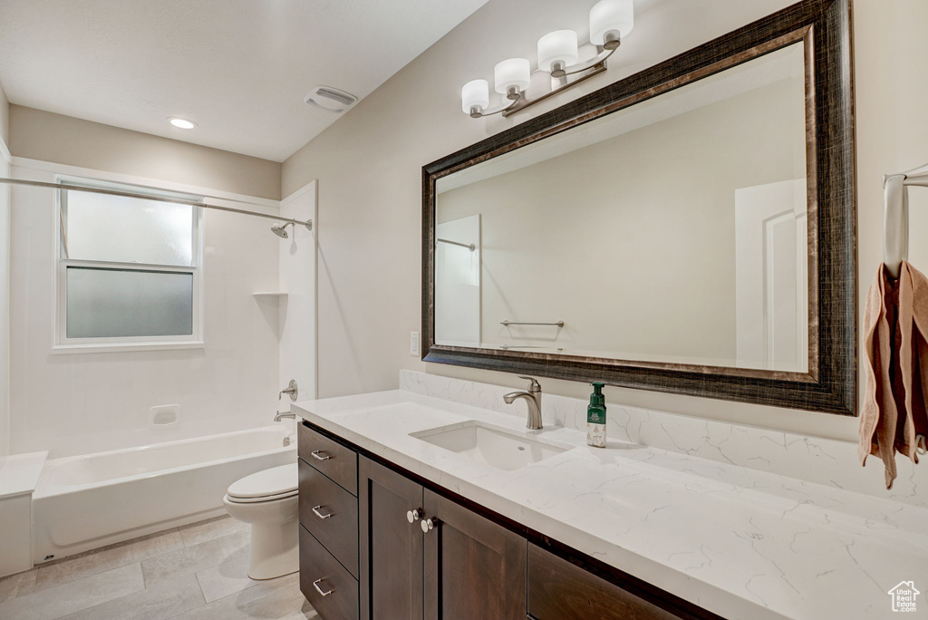 Full bathroom with tile floors, toilet, shower / bathing tub combination, and vanity