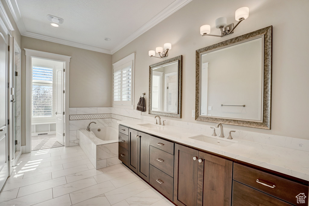 Bathroom featuring ornamental molding, tile floors, dual vanity, and tiled bath