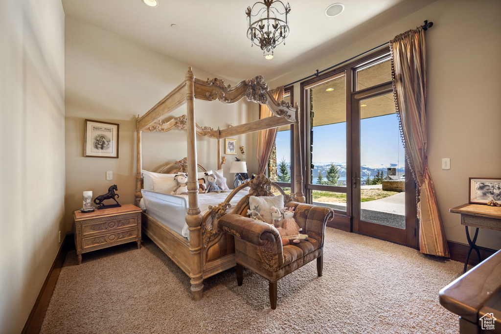 Carpeted bedroom with a chandelier and access to exterior