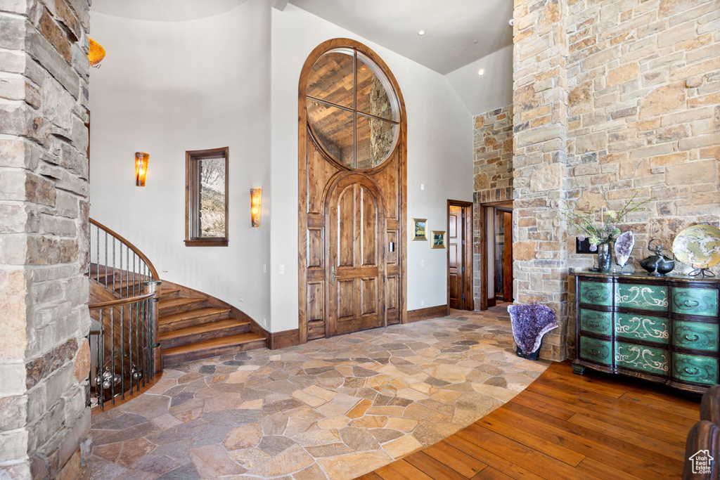 Entrance foyer with hardwood / wood-style floors and a towering ceiling