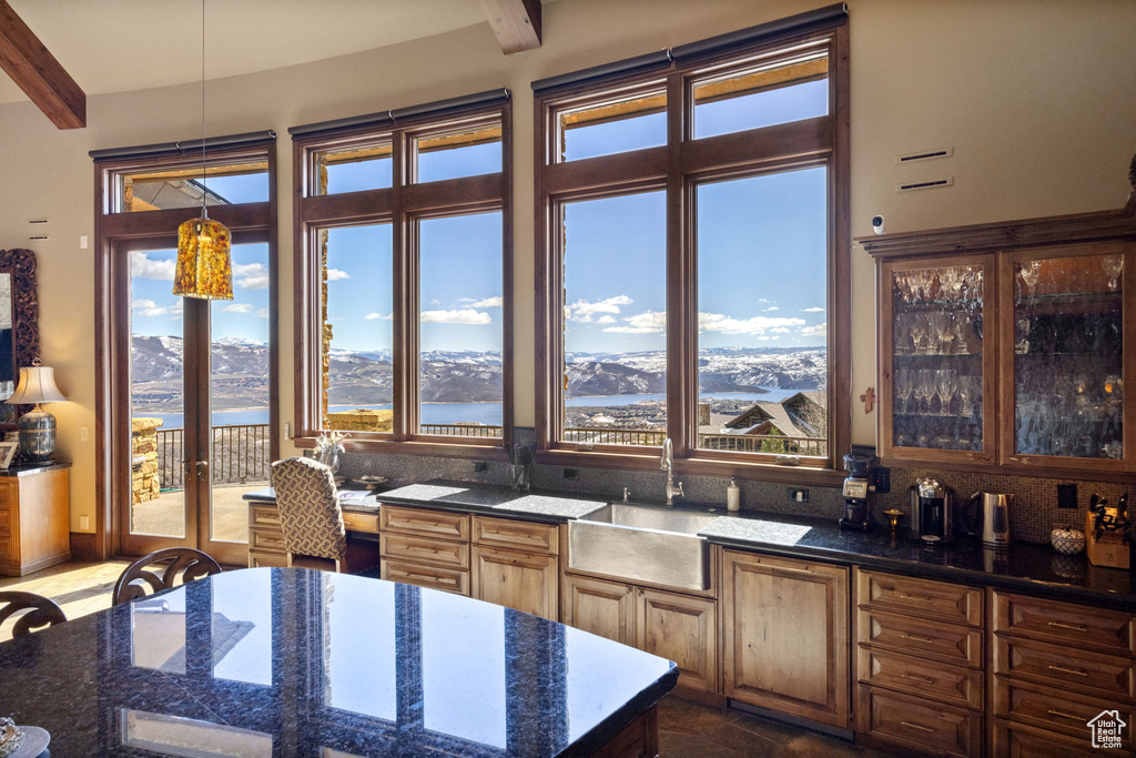 Kitchen featuring beamed ceiling, a water and mountain view, and dark stone counters