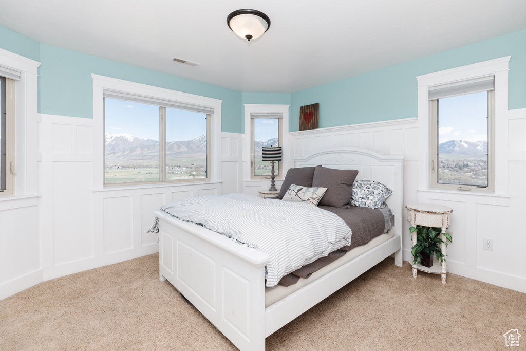 Bedroom featuring light colored carpet and a mountain view