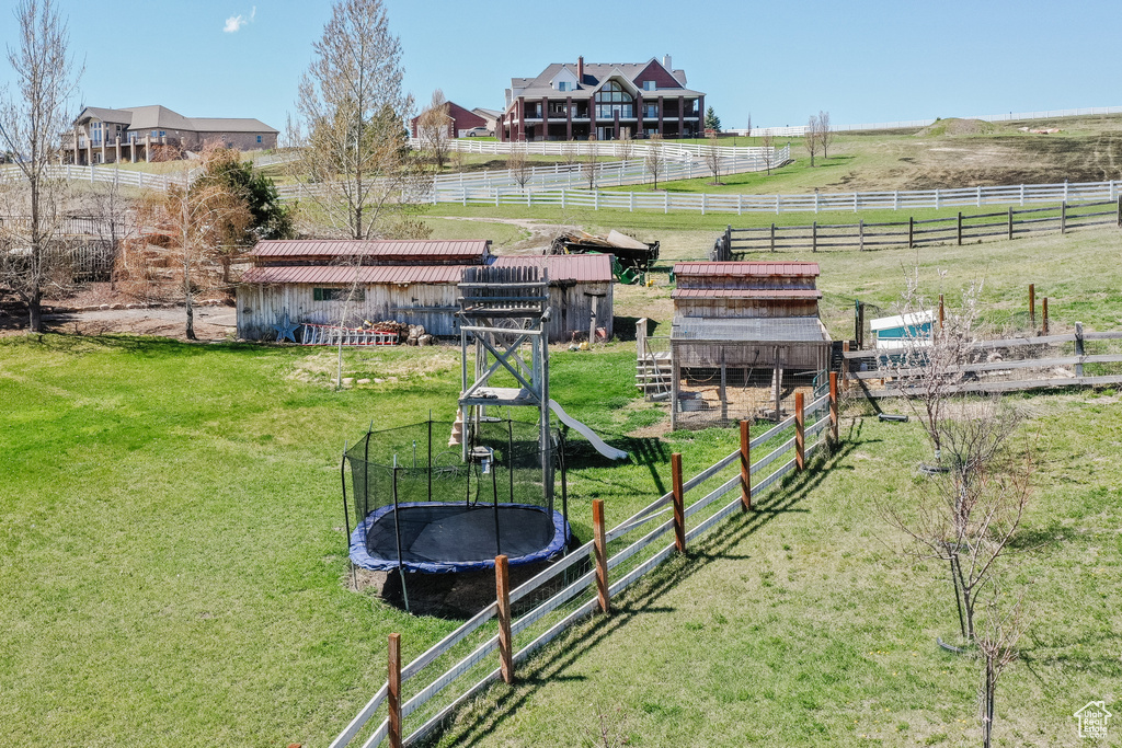 View of yard with a trampoline and a rural view