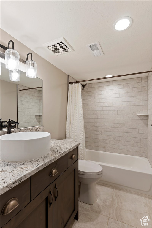 Full bathroom featuring tile flooring, oversized vanity, toilet, and shower / bathtub combination with curtain