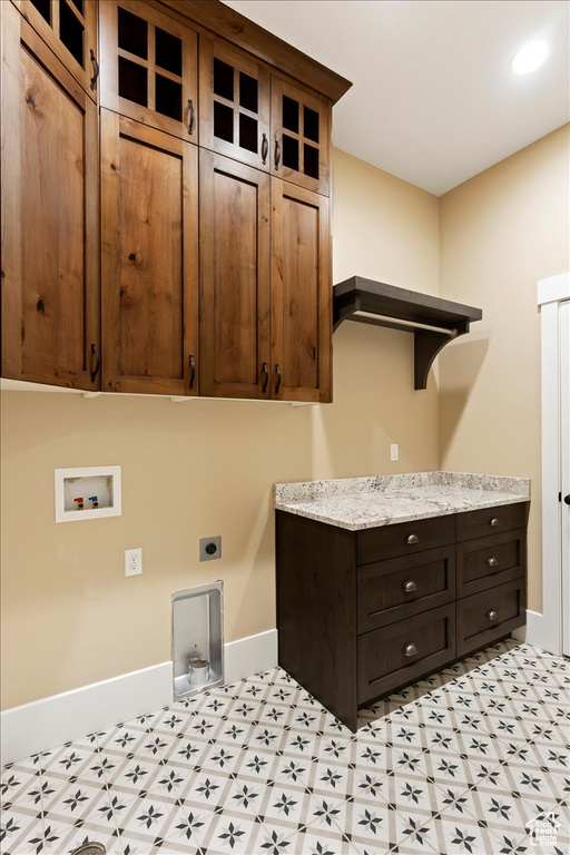 Washroom with hookup for an electric dryer, cabinets, and light tile floors