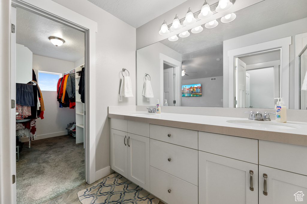 Bathroom with dual sinks, ceiling fan, and large vanity