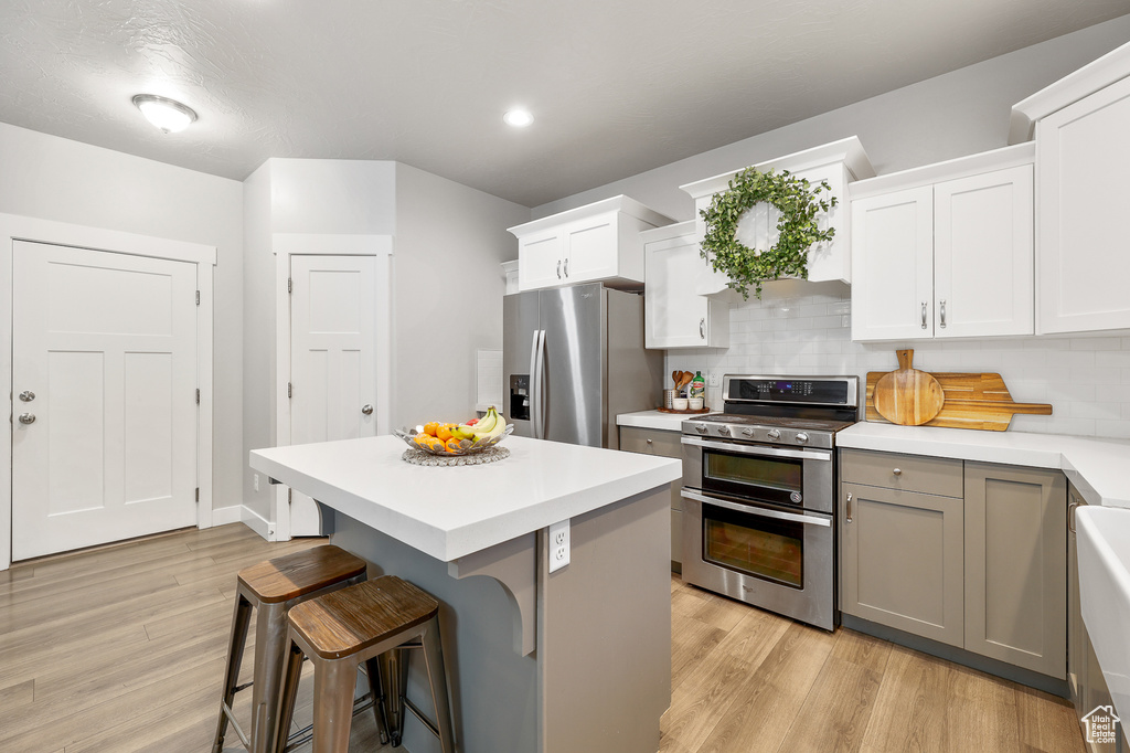 Kitchen featuring backsplash, light hardwood / wood-style flooring, and stainless steel appliances