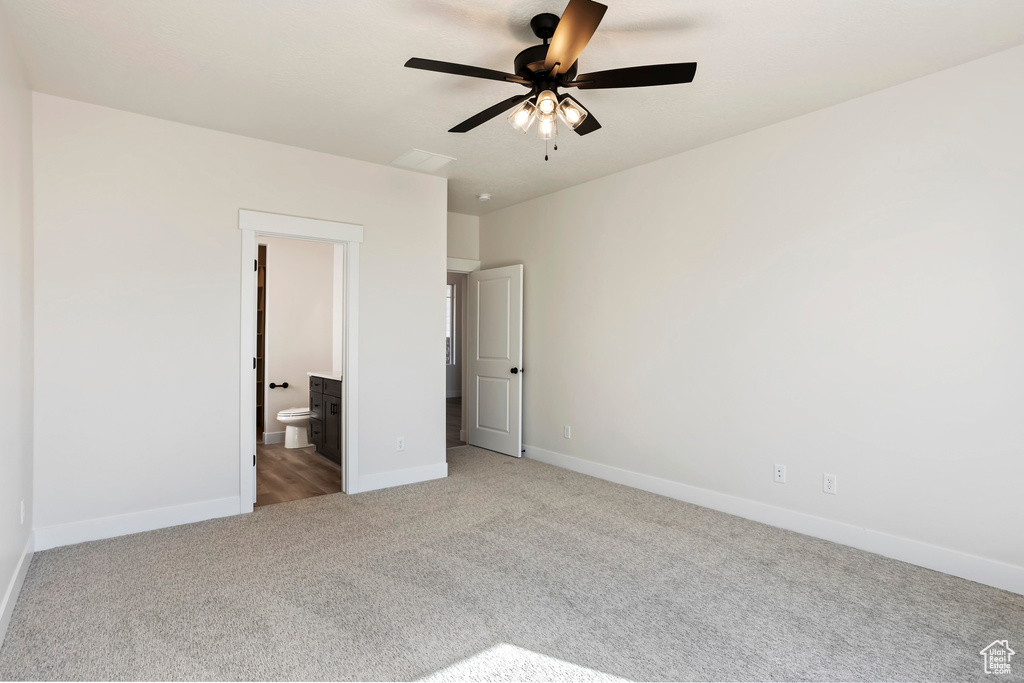 Unfurnished bedroom with light carpet, ceiling fan, and ensuite bath