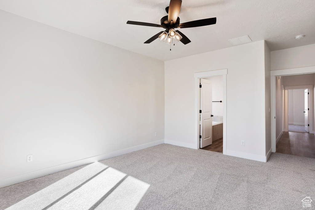 Unfurnished room featuring dark colored carpet and ceiling fan