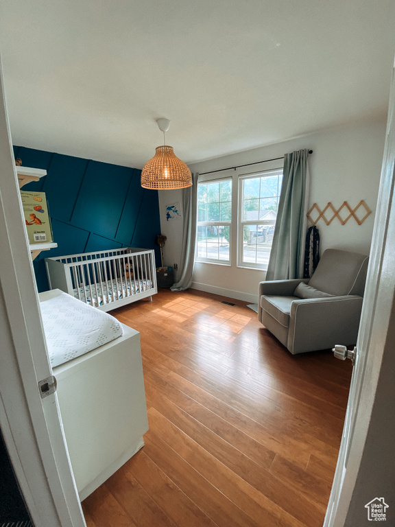 Bedroom featuring light wood-type flooring and a nursery area