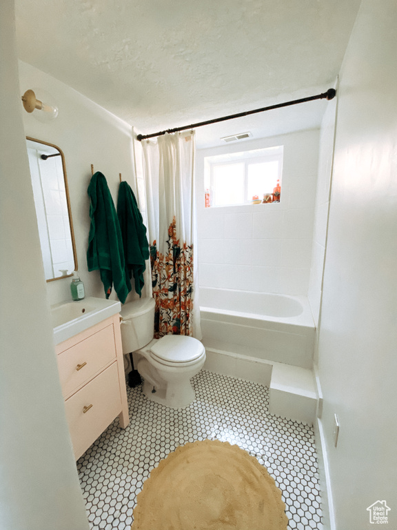 Full bathroom featuring vanity, shower / bath combination with curtain, toilet, and tile flooring