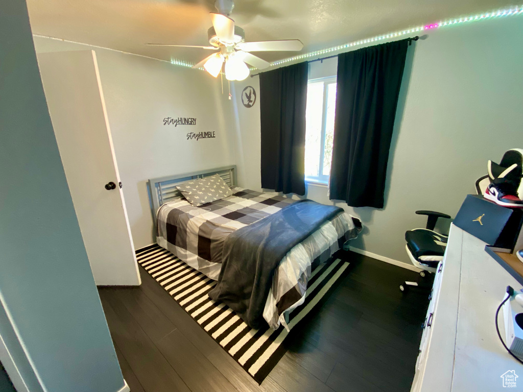 Bedroom with dark hardwood / wood-style flooring and ceiling fan