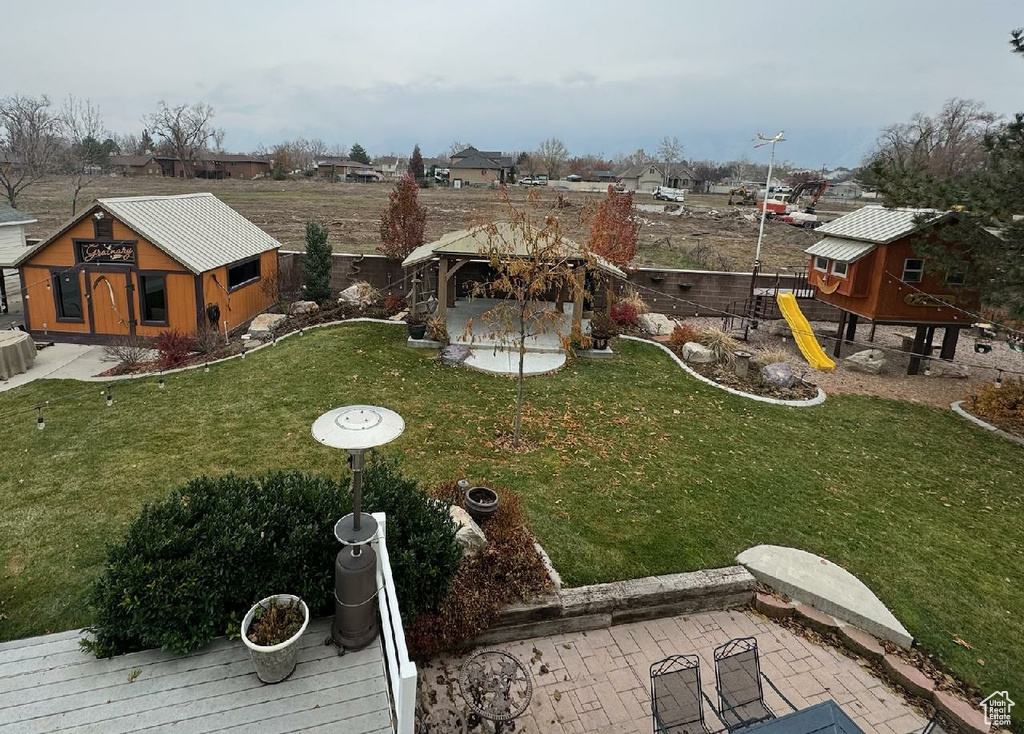 View of yard with a playground, an outdoor structure, and a patio