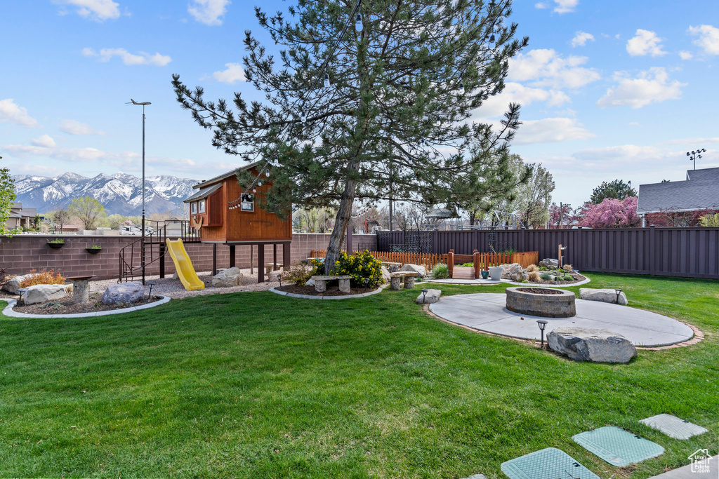 View of yard with a mountain view and an outdoor fire pit
