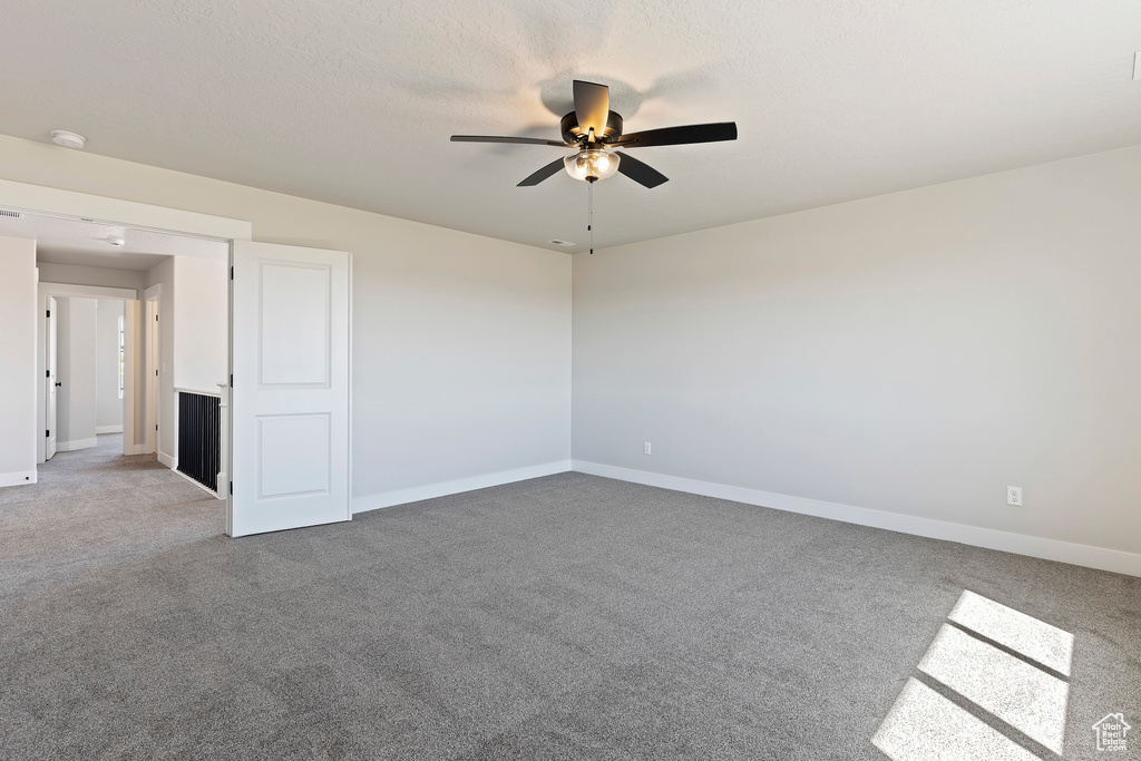 Carpeted empty room with ceiling fan