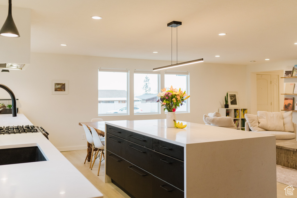Kitchen featuring a kitchen island, light hardwood / wood-style floors, and decorative light fixtures