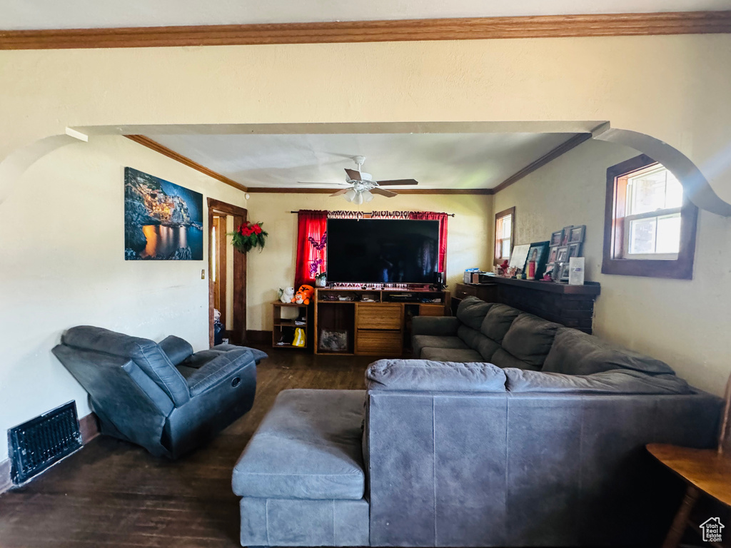 Living room featuring ceiling fan, dark hardwood / wood-style flooring, and ornamental molding