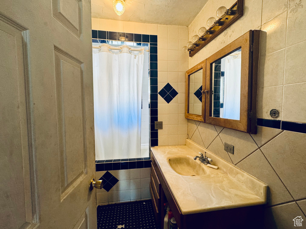 Bathroom featuring oversized vanity and tile walls