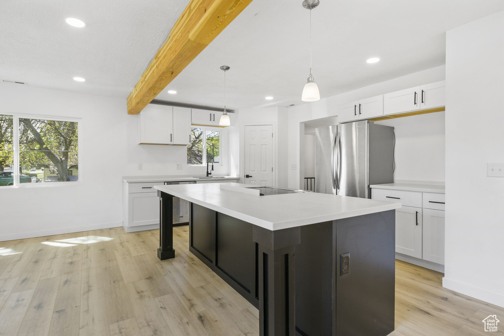 Kitchen featuring white cabinets and beam ceiling