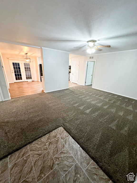 Interior space featuring ornamental molding, ceiling fan, and carpet flooring
