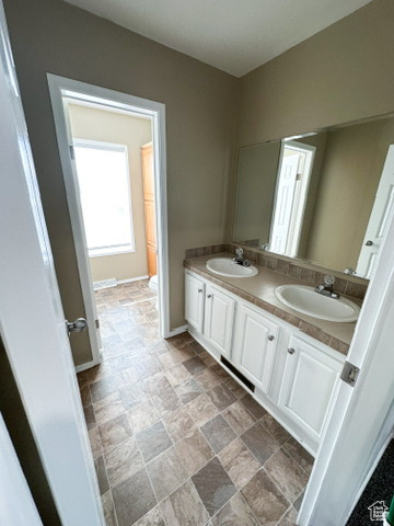 Bathroom with oversized vanity, tile floors, and double sink