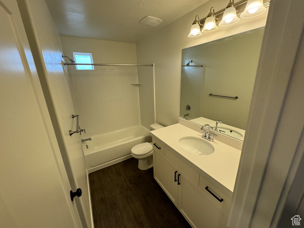 Full bathroom featuring  shower combination, oversized vanity, hardwood / wood-style flooring, and toilet