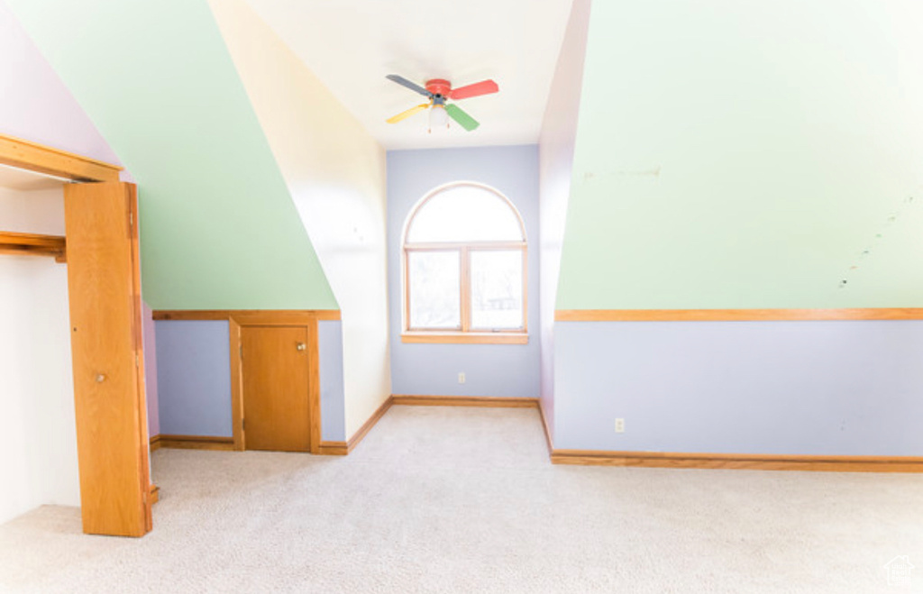 Additional living space featuring light colored carpet and ceiling fan