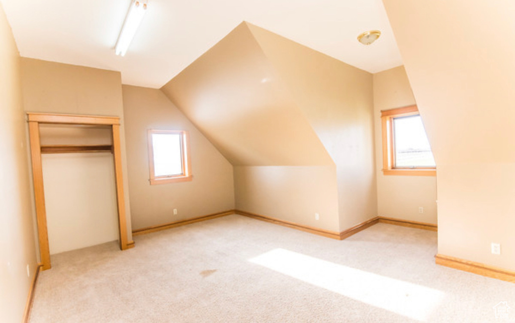 Bonus room featuring light carpet and vaulted ceiling
