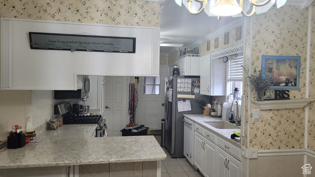 Kitchen with gas stove, light tile flooring, white cabinetry, and sink