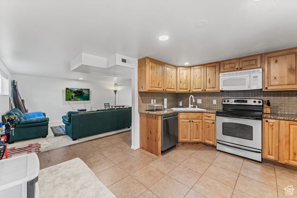 Kitchen with dishwasher, light tile floors, and electric range