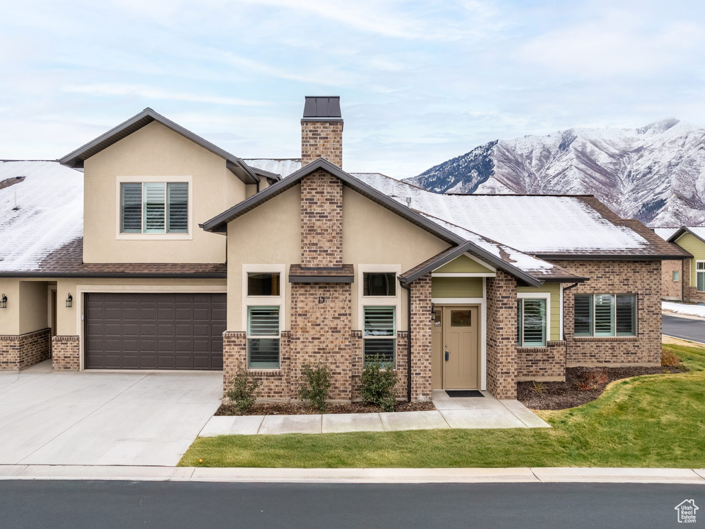 View of front of home with a mountain view and a garage