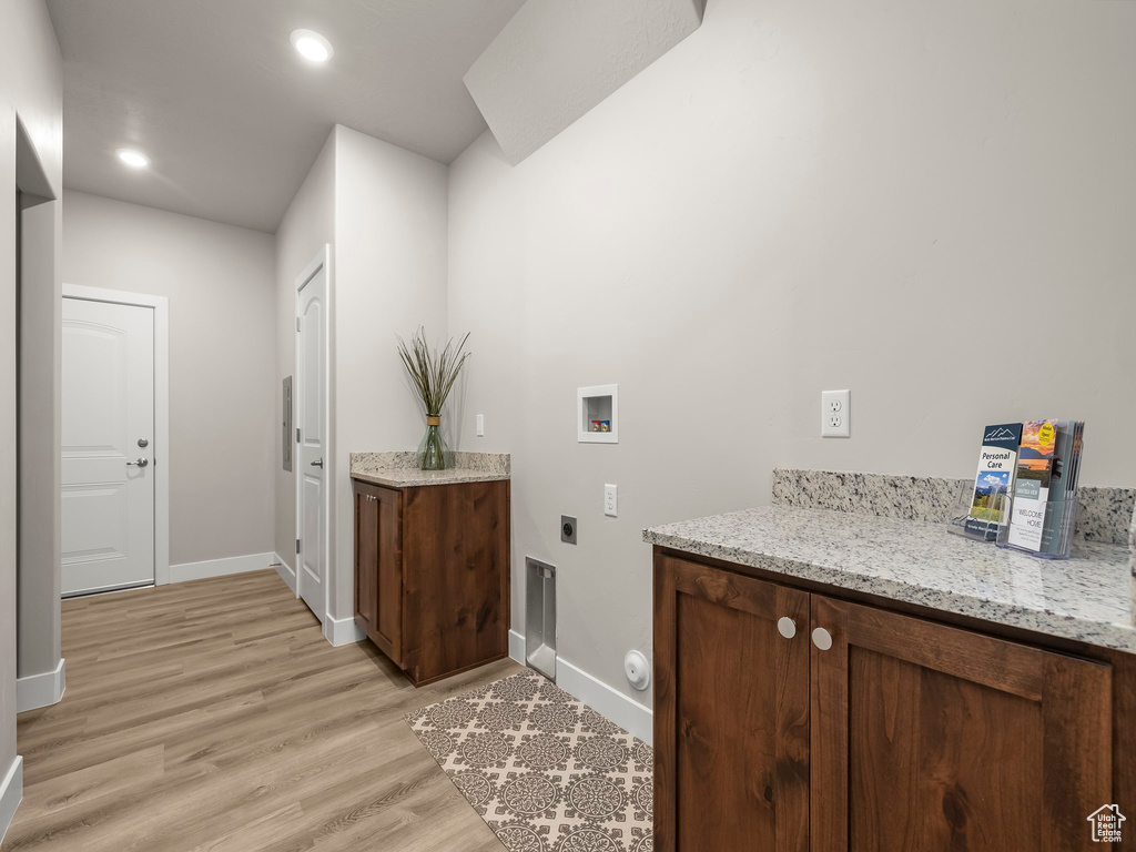 Washroom featuring hookup for an electric dryer, washer hookup, and light hardwood / wood-style floors