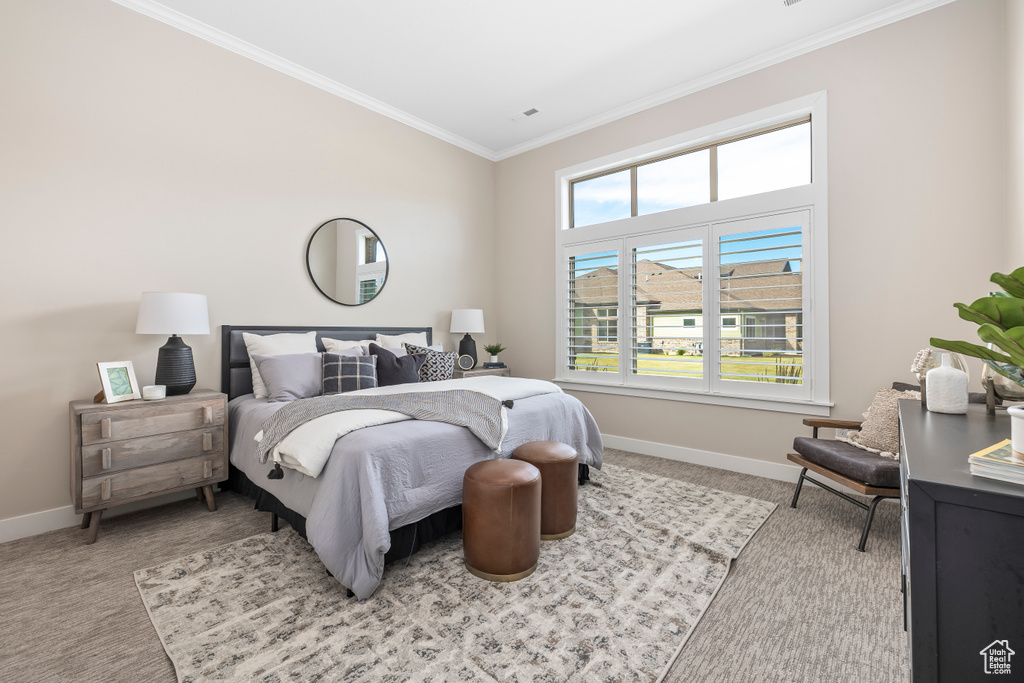 Bedroom with light colored carpet and crown molding