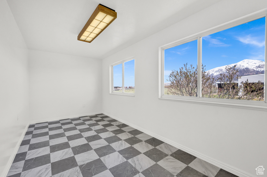 Tiled spare room featuring a mountain view
