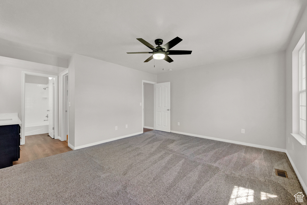 Spare room featuring ceiling fan and dark carpet