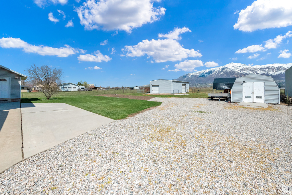View of yard with a mountain view, a storage shed, and a garage
