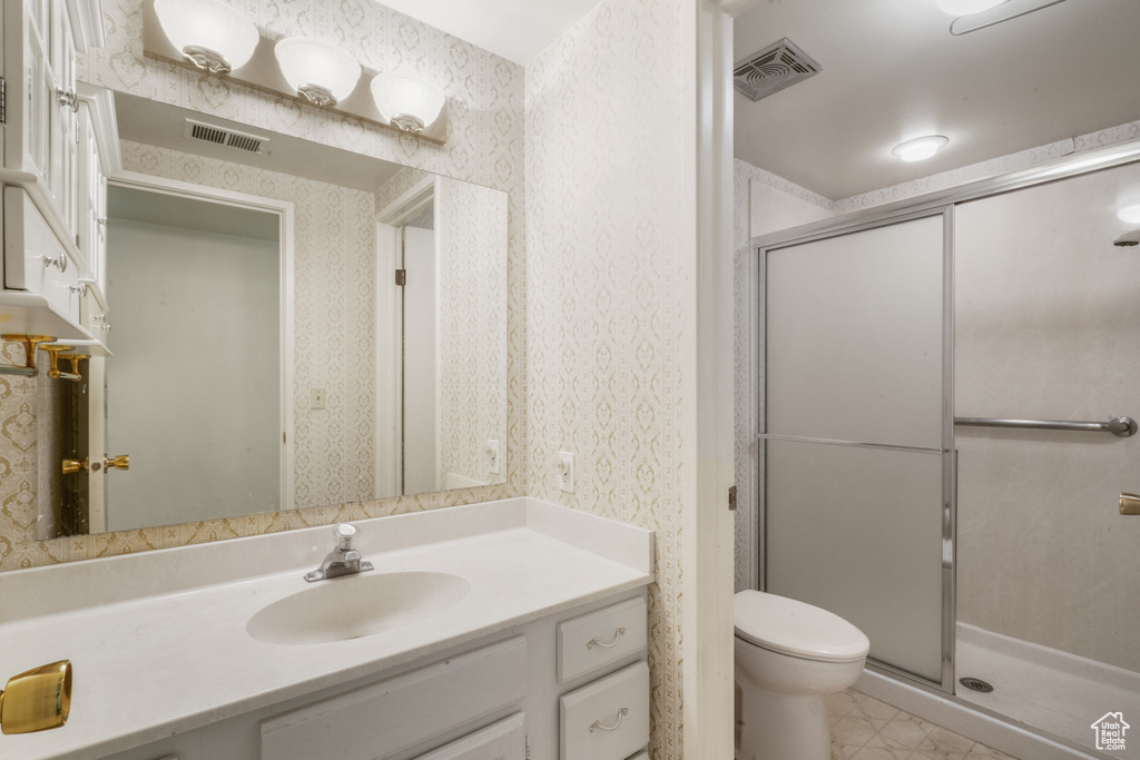 Bathroom featuring walk in shower, vanity, toilet, and tile floors