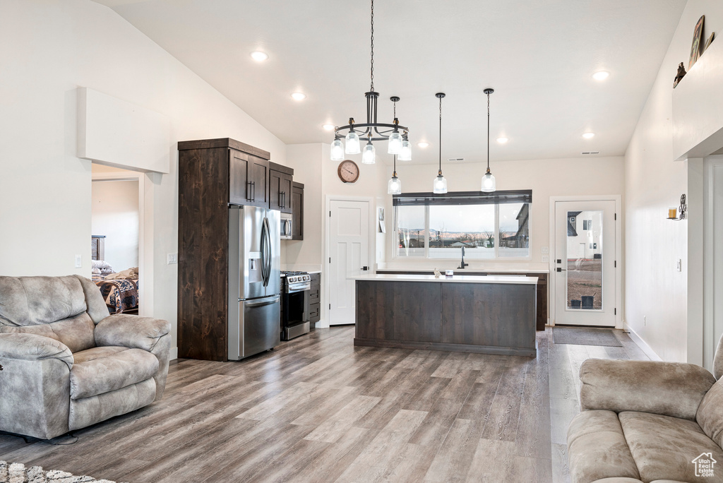 Interior space with a chandelier, light hardwood / wood-style flooring, high vaulted ceiling, and sink