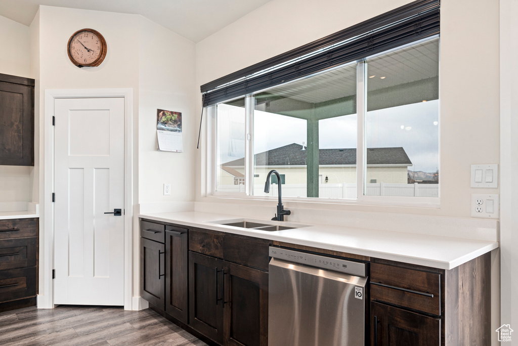 Kitchen featuring stainless steel dishwasher, sink, dark hardwood / wood-style floors, and dark brown cabinets