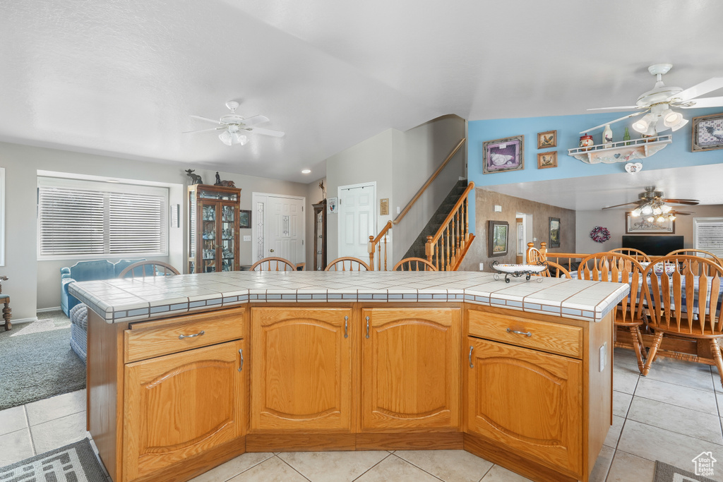 Kitchen with a kitchen island, tile countertops, and ceiling fan